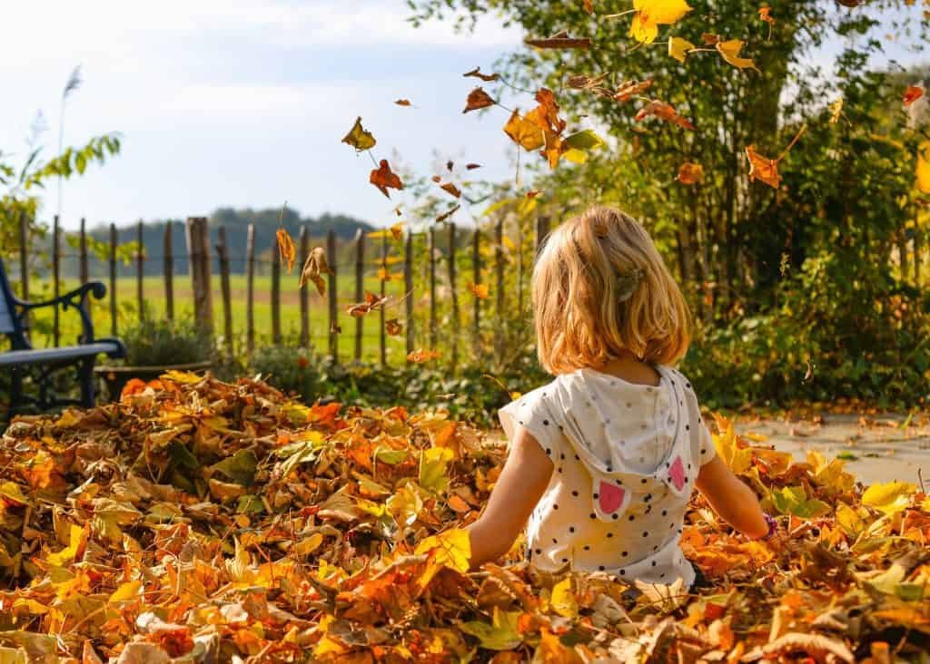 Girl playing with leafs outdoor